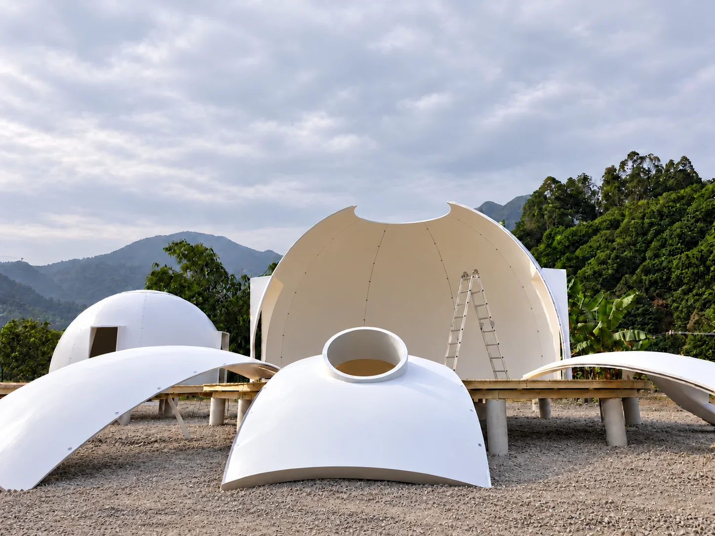 MarsDome panels assembled into an open half-dome, with a single aluminum A-frame ladder inside.