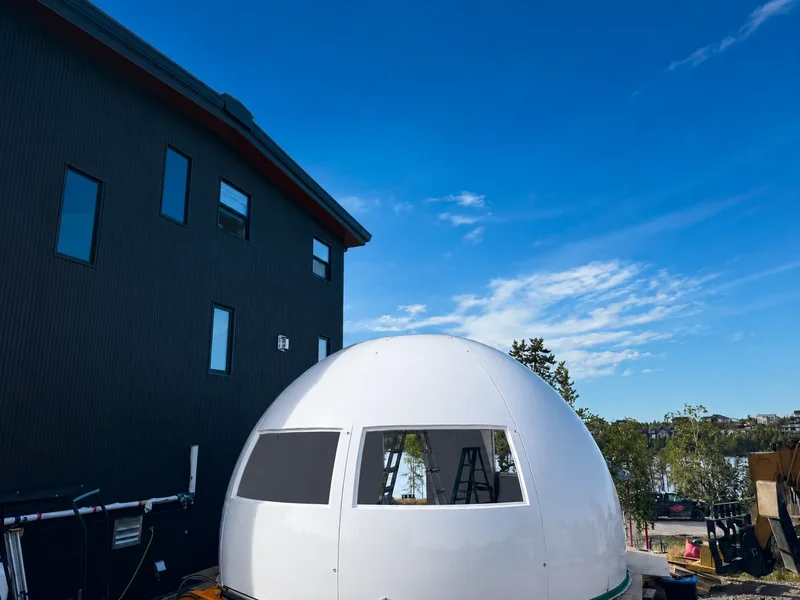 Assembled white MarsDome with window openings, shown in daylight.